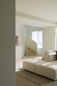 A modern neutral-tones living room with minimalist furniture and soft lighting.