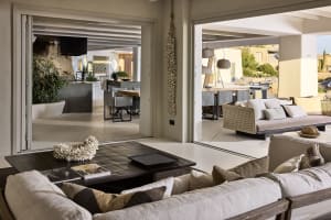 A modern residential room featuring neutral textiles and concrete flooring, with a focus on comfort and minimalist design.