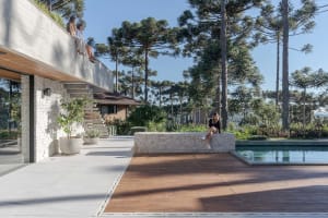 A minimalist residential exterior features concrete, glass, and wood materials.