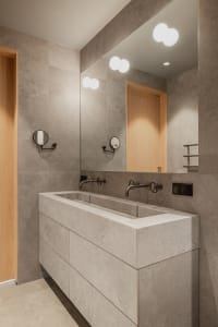 Modern bathroom with a concrete sink and tiled walls