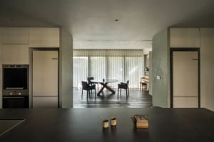 Modern kitchen with minimalist design featuring concrete, wood, and glass materials