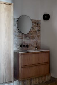 A modern floating bathroom vanity with a wooden finish.