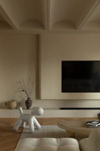 A minimalist residential interior with a concrete floor, wooden furniture, and a floor-to-ceiling window.