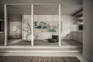 Minimalist living room featuring a wooden floor and furniture, with a large tapestry and a green beanbag chair.