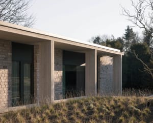 A modern building with a brick exterior, featuring clean lines and large windows.