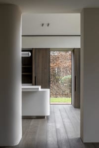 A modern residential entryway featuring wood and concrete materials, with minimalist design elements.