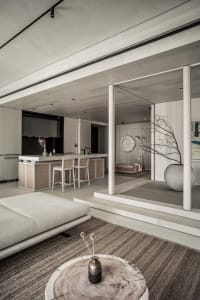 A modern interior living room with minimalist design and wooden materials, featuring a sofa, coffee table, and decorative vas