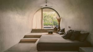 Modern concrete bedroom with a minimalist design and natural light.