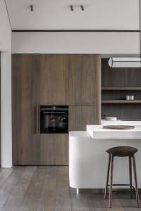 A modern kitchen with wooden cabinets and a white countertop.