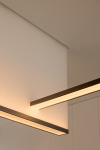 Modern, minimalist interior design featuring sleek, metallic lighting fixtures.