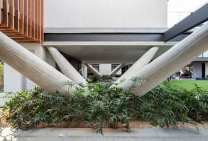 Modular, contemporary residential exterior with concrete columns supporting the upper floor.