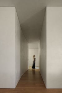 A minimalist hallway with concrete walls and wooden flooring