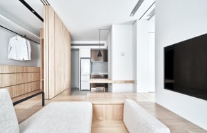 Modern minimalist apartment featuring a white wood floor, white walls, and white minimalist furniture, with a white refrigera