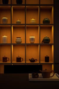 Traditional tea ceremony setting featuring clay jars and shelves.