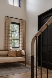 A modern living room with natural fiber curtains and woven cane furniture.