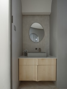 Minimalist bathroom with concrete walls and a modern square sink on a wooden vanity.