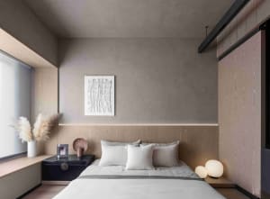 A minimalist bedroom with a wooden headboard, white bedding, and a window with white blinds.