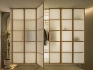 Modern interior design featuring a glass-paneled wardrobe with brown wooden accents.