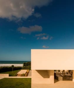 Modern residential building with extensive glass façade and stone elements.