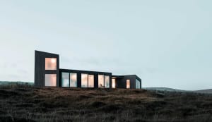 Modern house exterior featuring expansive windows, black structure, and minimalist design.