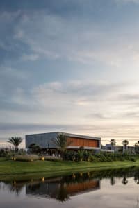 Modern house with concrete structure near a calm body of water.