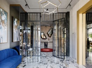 Modern lobby interior with glass doors, metal frame, and geometric lighting.