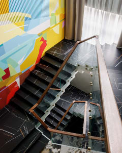 A modern staircase with glass railings and marble steps.
