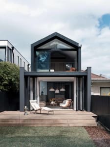 Modern residential exterior featuring a combination of glass and wood materials with a contemporary design.