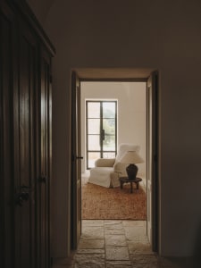 Interior of a minimalist room with a cabinet, glass window, and wooden floors.