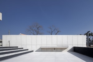 Modern minimalist architecture with concrete walls and steps, featuring a concrete bench and minimalist design elements.