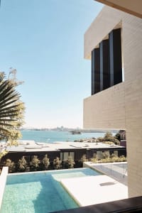 Modern residential exterior featuring cliff-side apartments with glass and stone materials.