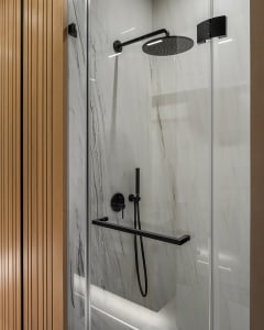 Modern bathroom shower with marble tiles and black steel fixtures