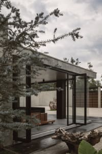 Concrete and glass minimalist residential facade under cloudy skies.