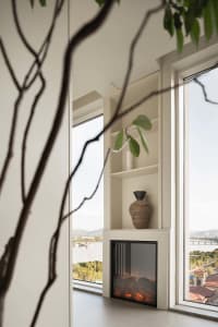 Modern ceramic vase sitting on a white console table in a living room.