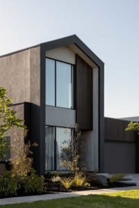 Modern house exterior with concrete walls and wooden accents.