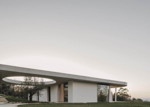 Modern, minimalist house with concrete walls and circular windows.