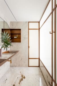 A modern bathroom featuring marble walls and flooring with minimalist design elements.