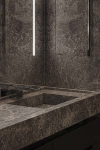 Modern bathroom with grey marble walls and a built-in sink.