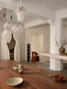A modern residential interior featuring a combination of wooden, concrete, and plaster elements.