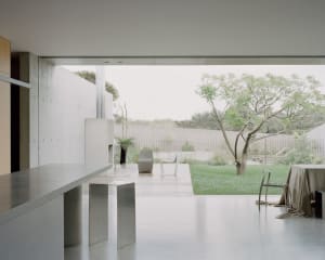 Clean, minimalist residential space featuring modern furniture and a seamless integration of indoor and outdoor elements.