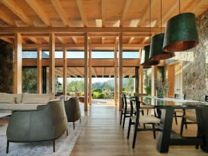 Modern interior with wooden beams, sofas, tables, and chairs.
