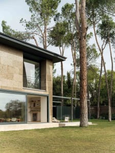 Contemporary residential exterior featuring large windows and stone cladding.