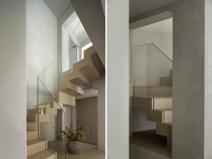 Modern staircase with glass railings and wooden steps in a minimalist design.