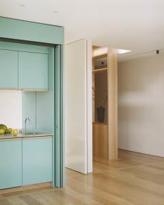 Modern kitchen featuring sleek, minimalist design with lacquered wood cabinets and a glass countertop.
