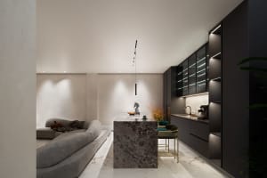 A modern residential kitchen featuring concrete and dark marble materials.