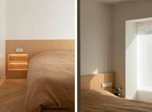 Modern, minimalist bedroom featuring wooden headboard and beige bedding.