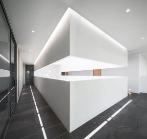 A minimalist office interior featuring concrete walls and flooring.