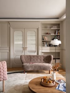 A cozy, modern living room featuring a carpeted floor, a fabric sofa, and a wooden coffee table.