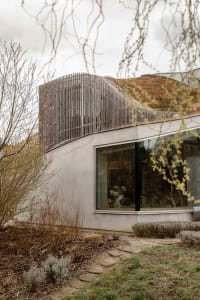 Modern house with concrete facade and large windows.