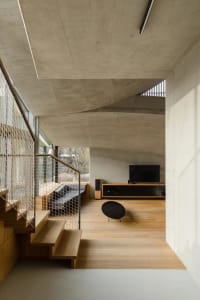 Modern interior space featuring concrete walls and wood flooring.